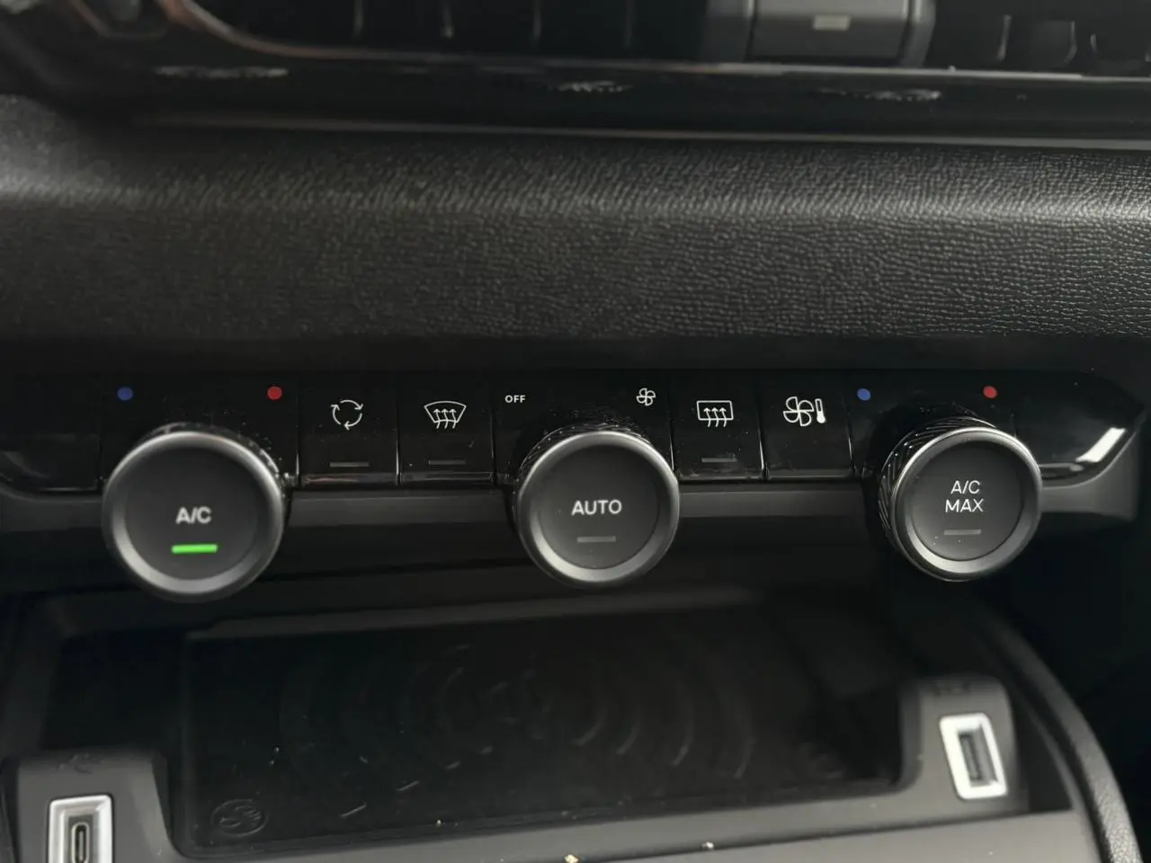 Gros plan sur les commandes de climatisation automatique de la Citroën C4 Hybrid 2025 en gris Mercury, avec boutons rotatifs A/C.