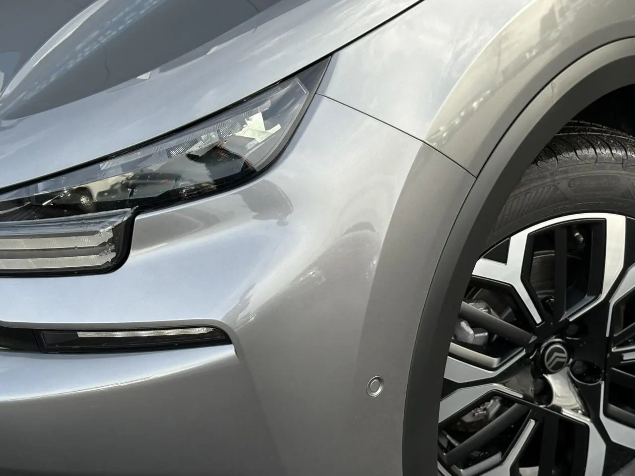 Gros plan sur l'avant droit gris Mercury du Citroën C4 2025, mettant en valeur le phare LED et la jante alliage diamantée.