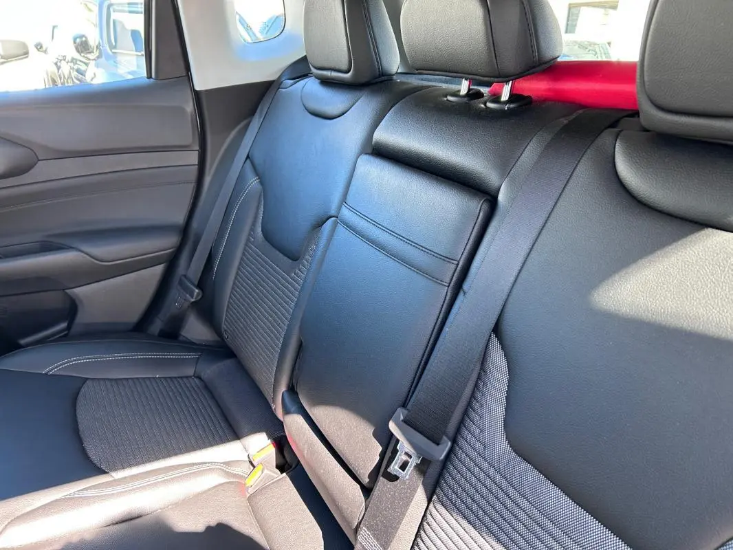 Vue intérieure côté droit des sièges arrière en cuir noir du Jeep Compass 2024 avec accoudoir central rabattable.