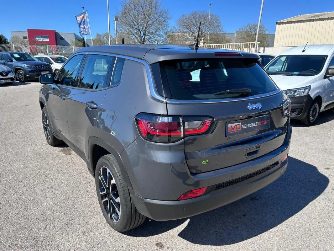 Vue 3/4 arrière droite d'un Jeep Compass gris 2024 avec jantes alliage 18 pouces et feux arrière LED.