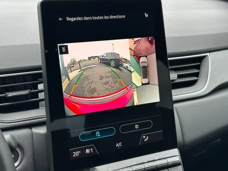 Écran tactile intérieur montrant la caméra de recul avec vue arrière et angles, tableau de bord gris du Renault Captur rouge.