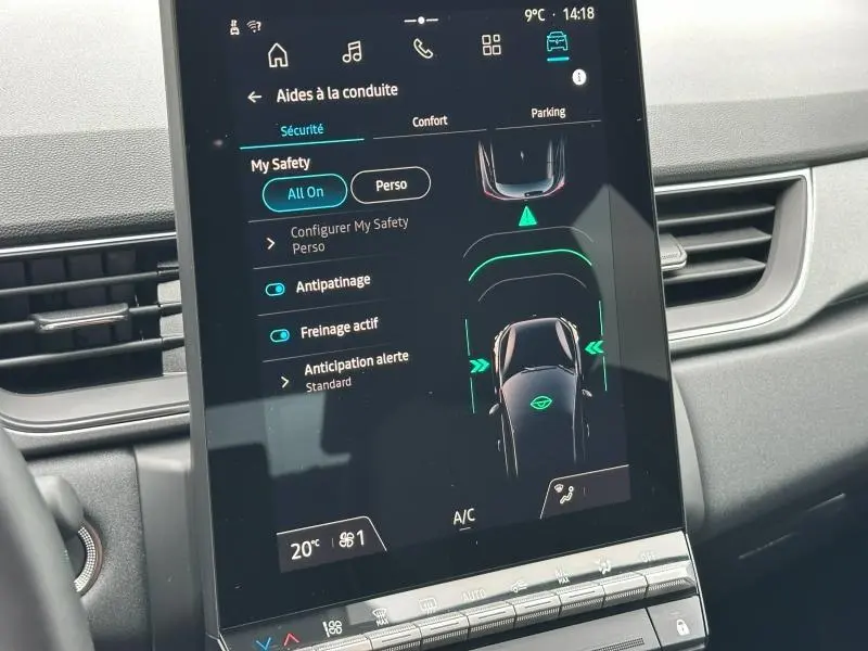 Écran tactile central du tableau de bord du Renault Captur rouge, affichant les aides à la conduite et la climatisation.
