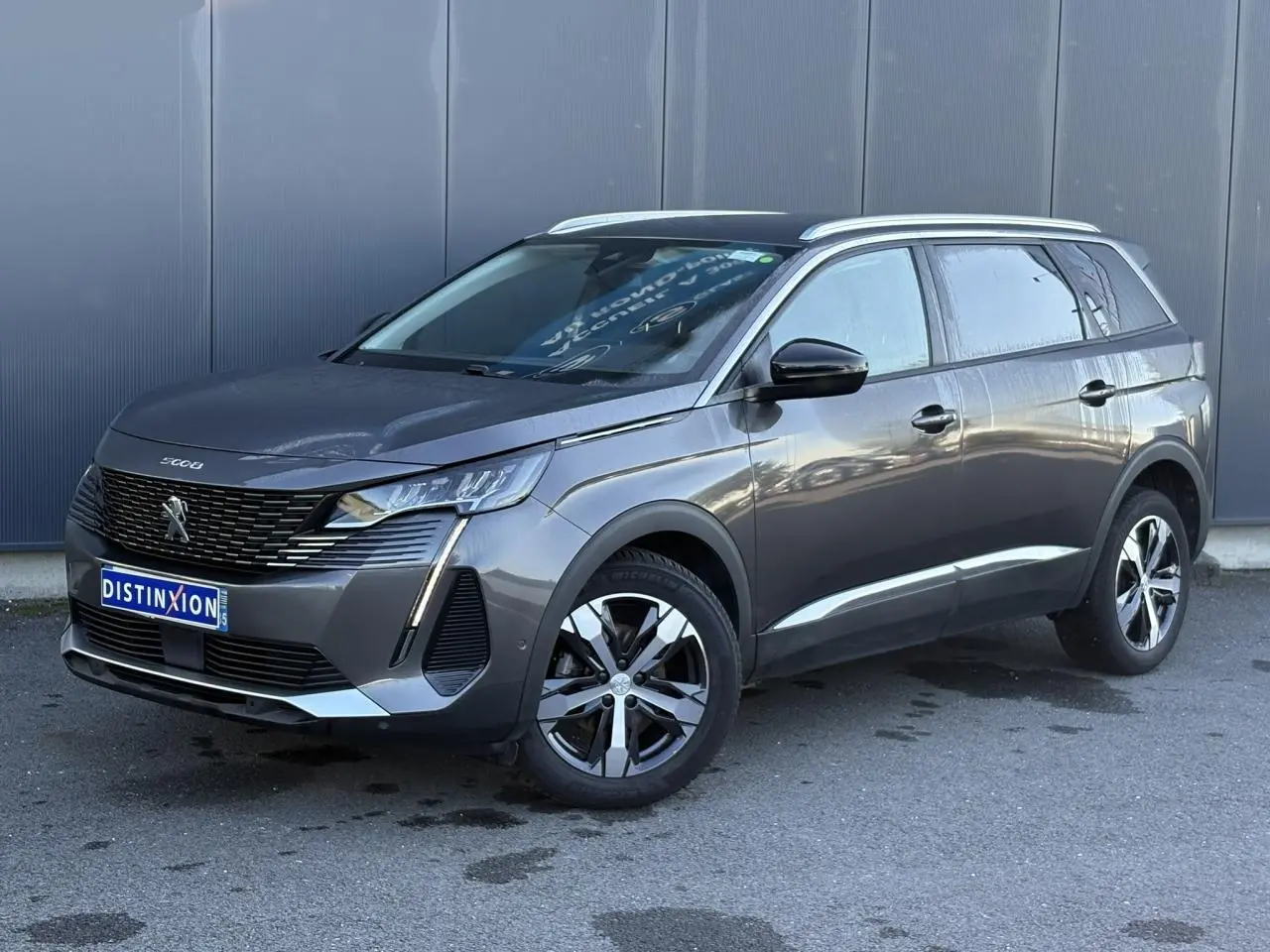Peugeot 5008 gris Platinium en 3/4 avant droit, avec jantes alliage bi-ton et toit surélevé.