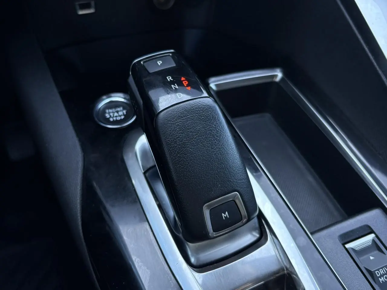 Le levier de vitesses automatique noir du Peugeot 5008 2022 vu en gros plan dans l'habitacle gris.