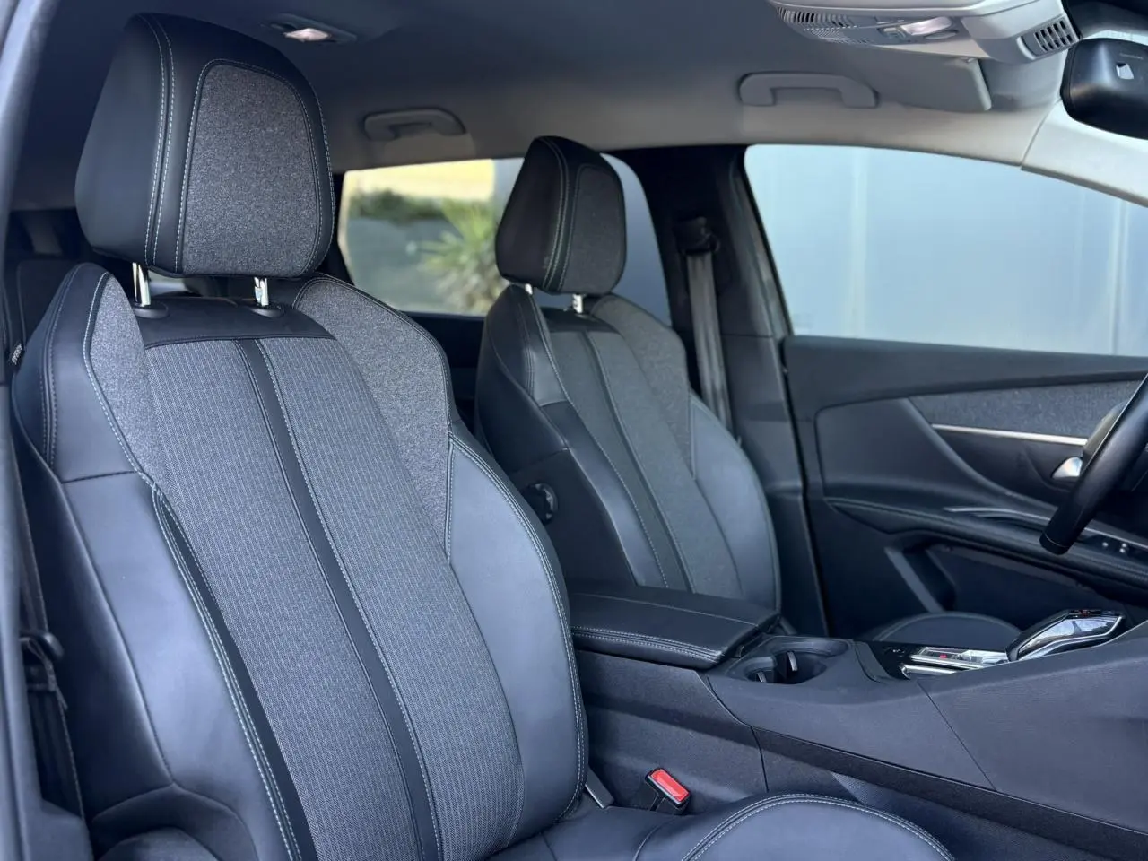 Vue intérieure côté droit du Peugeot 5008 2022, sièges avant en TEP et tissu gris avec coutures contrastées.