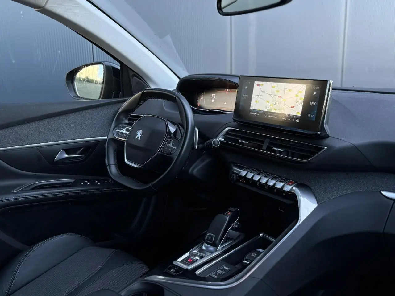 Vue intérieure côté conducteur du Peugeot 5008 2022 avec tableau de bord numérique et écran tactile central affichant la navigation.