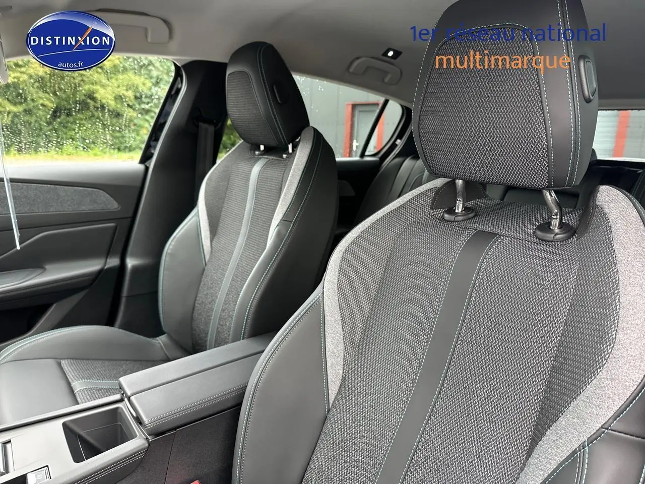 Gros plan sur les sièges avant gris et noirs avec surpiqûres bleues de la Peugeot 308 1.5 BlueHDi 130 Allure EAT8.