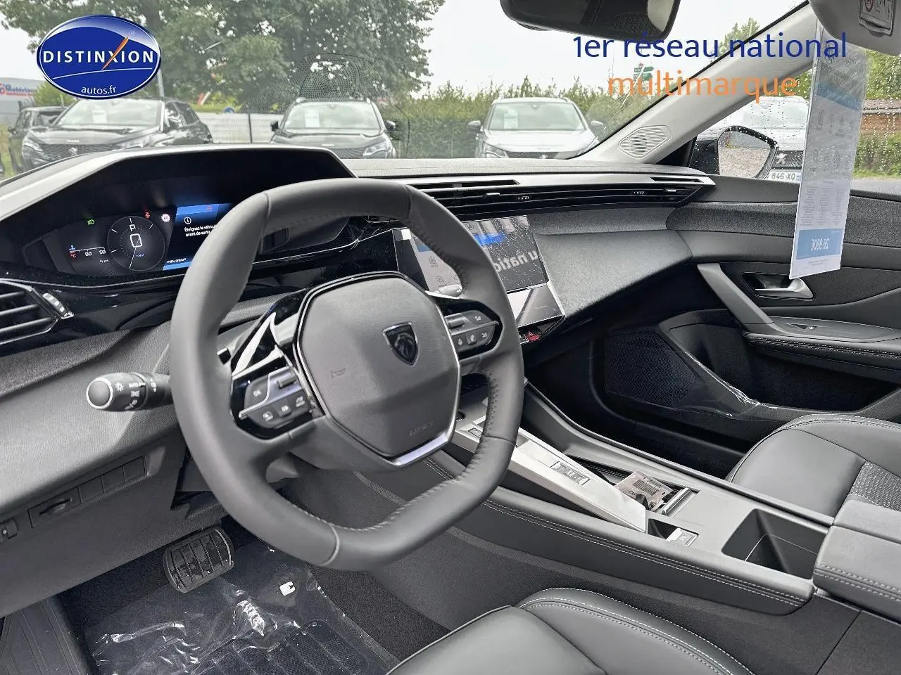 Intérieur noir de la Peugeot 308 2025, vue côté conducteur sur le volant multifonction et tableau de bord digital.