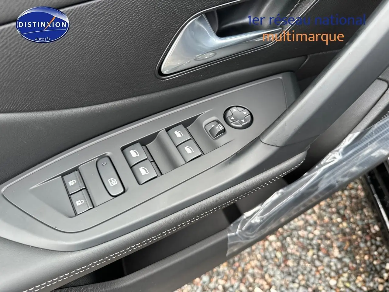 Gros plan sur la commande des vitres électriques et rétroviseurs côté conducteur d'une Peugeot 308 noire 2025