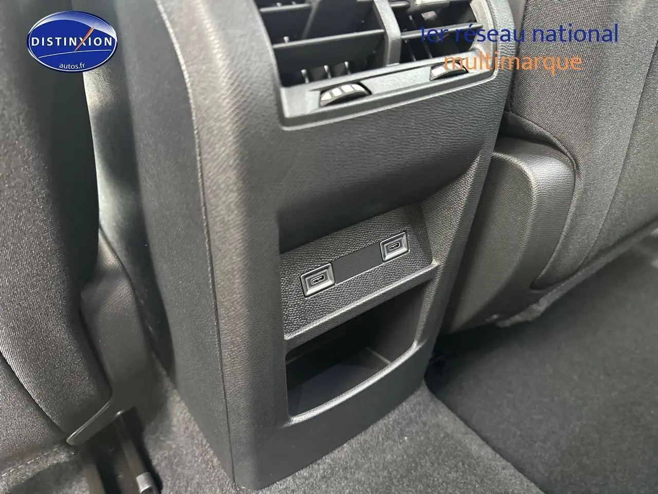 Prise USB arrière noire de la Peugeot 308 2025 vue en gros plan entre les sièges arrière.