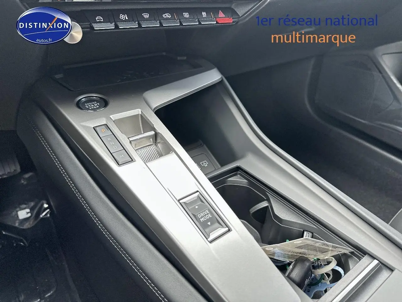 Vue rapprochée de la console centrale noire de la Peugeot 308 1.5 BlueHDi 130 Allure EAT8 avec levier de vitesses électronique.