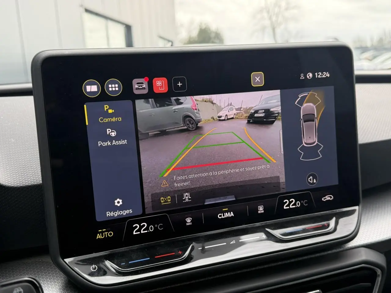 Écran tactile intérieur affichant la caméra de recul et l’aide au stationnement du SEAT Leon gris Magnétique.