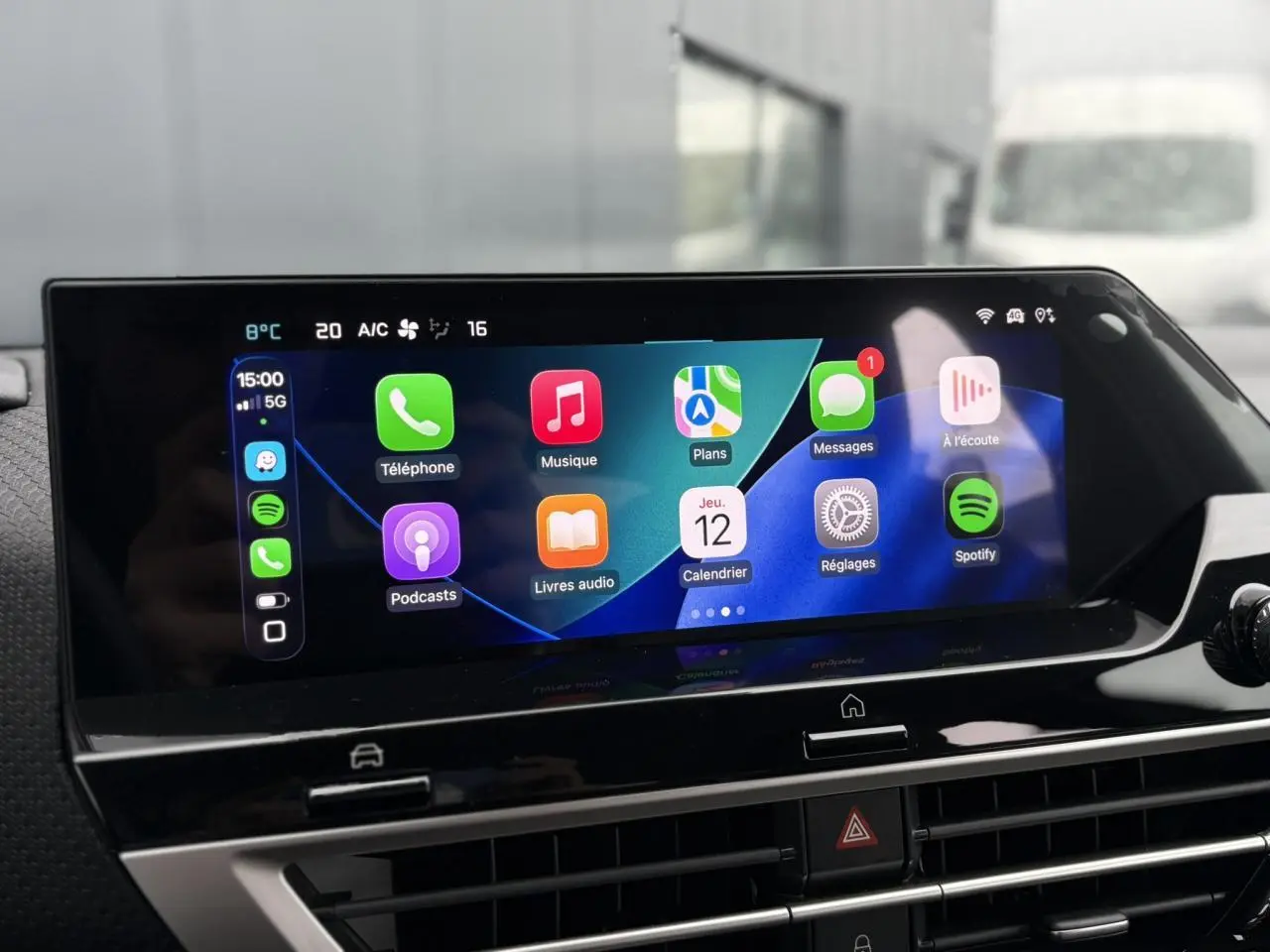 Écran tactile central affichant Apple CarPlay dans l'habitacle moderne de la Citroën C4 Hybrid 2025.