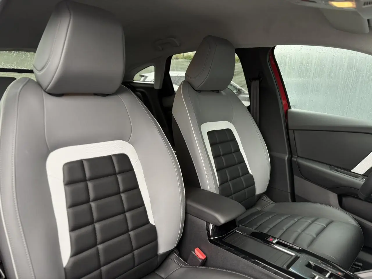 Vue intérieure rapprochée des sièges avant bi-ton gris clair et noir du Citroën C4 Rouge Elixir, côté droit visible.