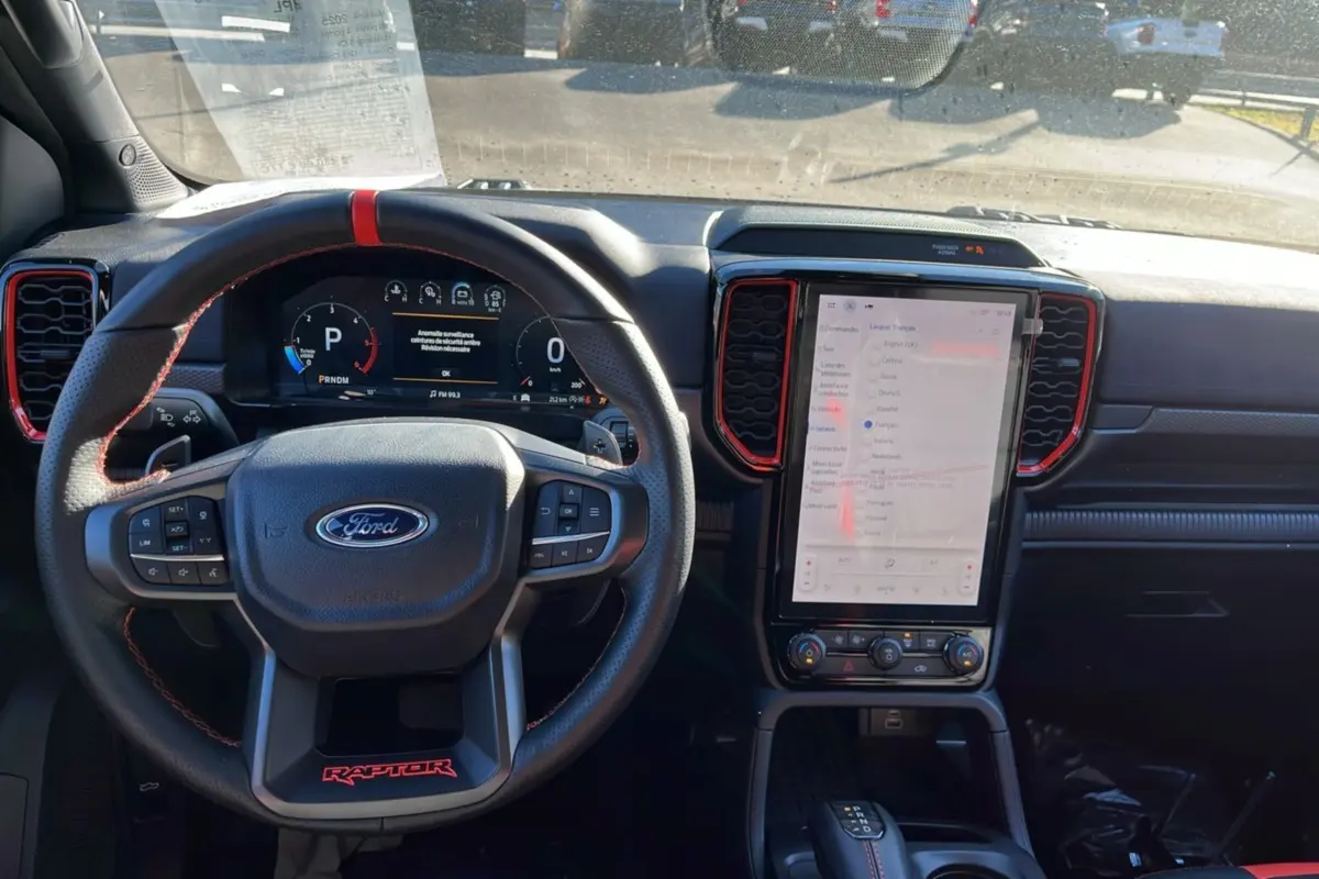 Vue intérieure centrée sur le volant cuir Raptor et l’écran tactile vertical du Ford Ranger gris commandeur 2025.