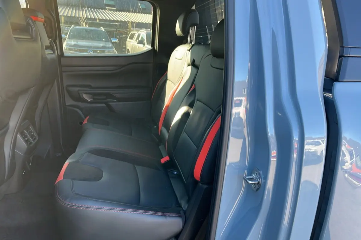 Vue intérieure côté gauche sur les sièges arrière noirs avec surpiqûres rouges du Ford Ranger Raptor 2025 gris commandeur.