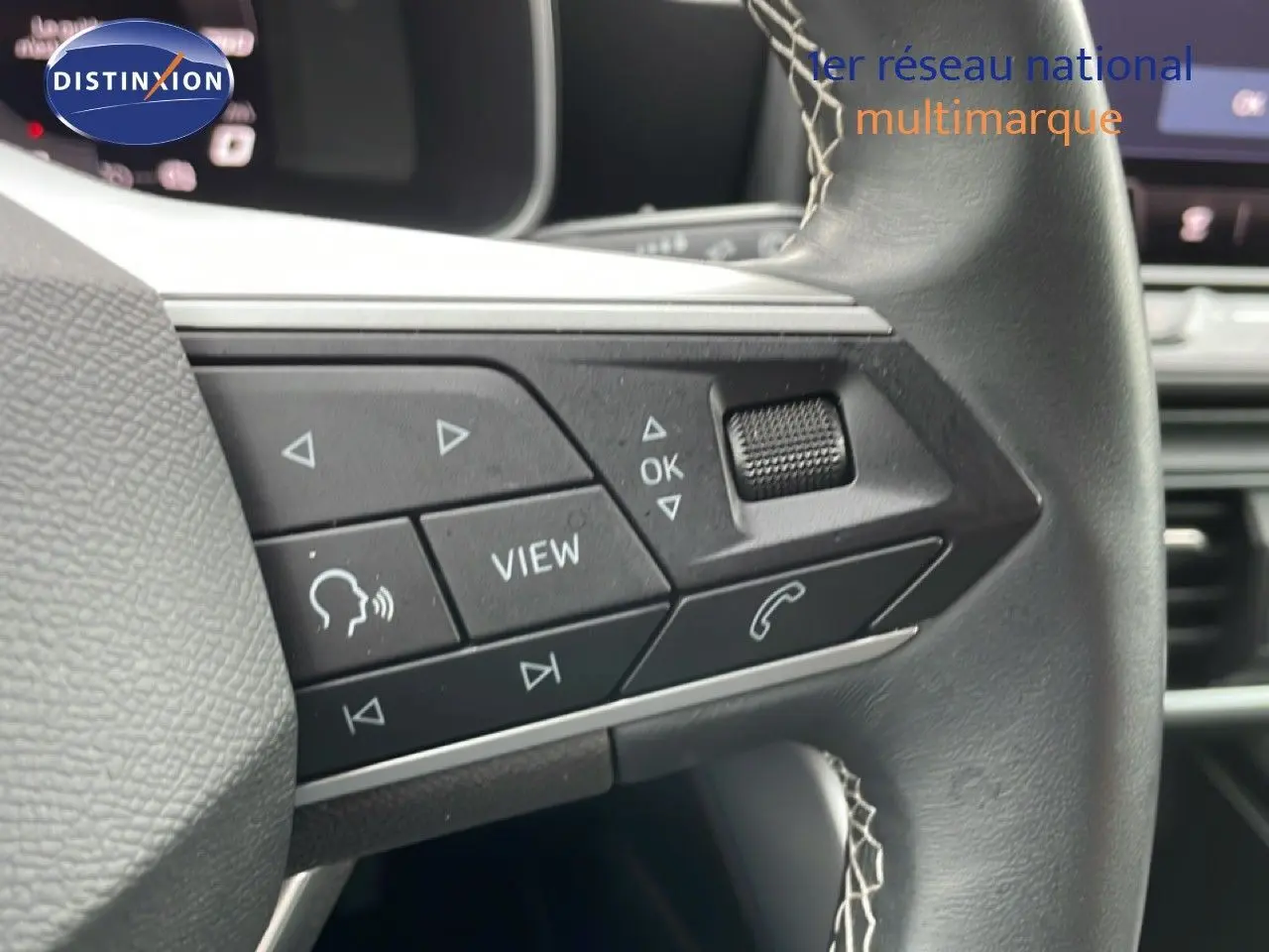 Gros plan sur les commandes multifonctions à droite du volant cuir d’une SEAT Leon 2025, intérieur gris noir.