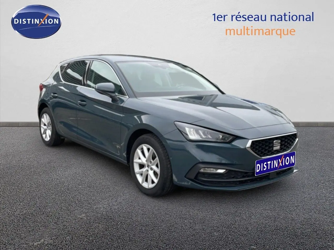 SEAT Leon 2.0 TDI gris magnétique métal vue 3/4 avant droit sur sol bitumé, calandre et phares LED visibles.