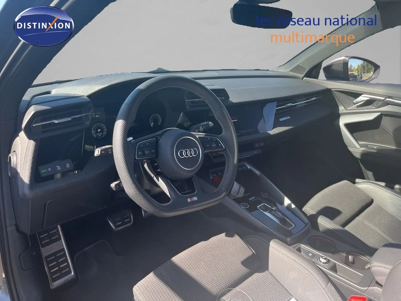 Vue intérieure de l'Audi A3 Sportback 2025, tableau de bord et volant S-Line en cuir noir avec finitions modernes.