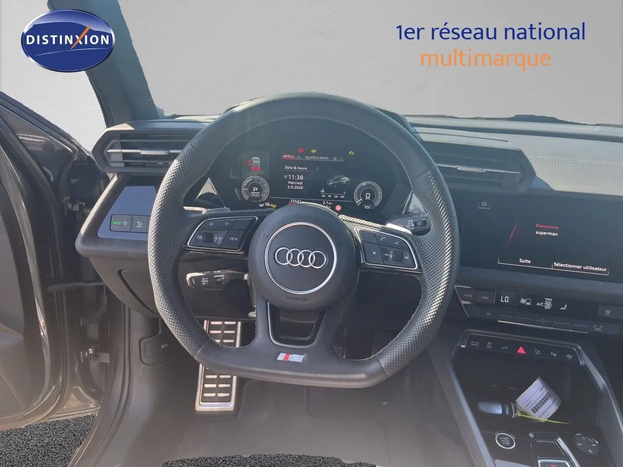 Vue intérieure centrée sur le volant S-Line et le tableau de bord numérique d'une Audi A3 Sportback gris Daytona.
