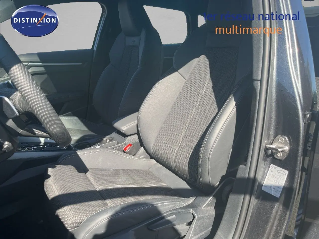 Vue intérieure côté conducteur de l'Audi A3 Sportback 40 TFSIe S-Line 2025, sièges en tissu et cuir noir.