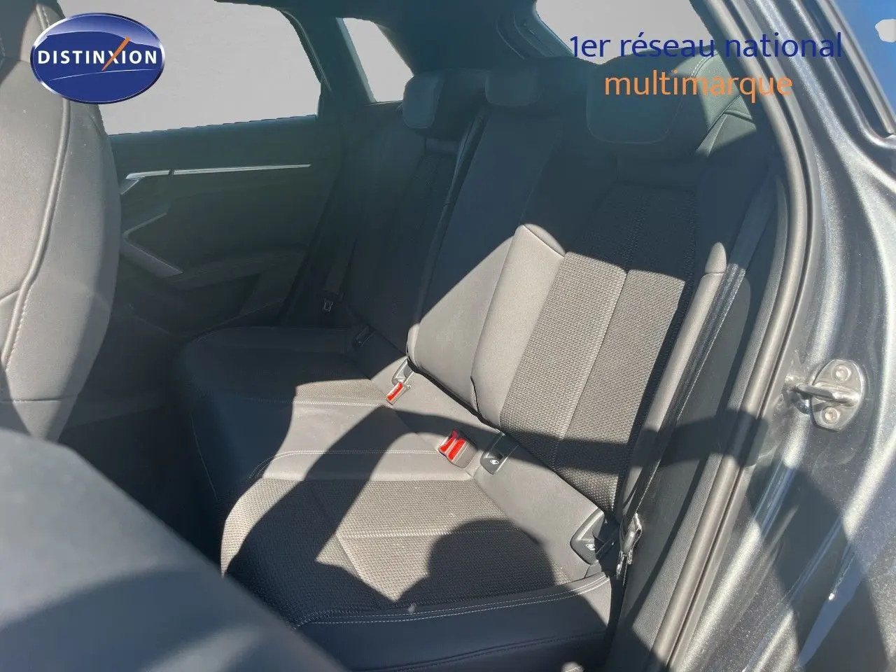 Vue intérieure sur la banquette arrière côté droit d'une Audi A3 Sportback gris Daytona, avec sellerie tissu noire.