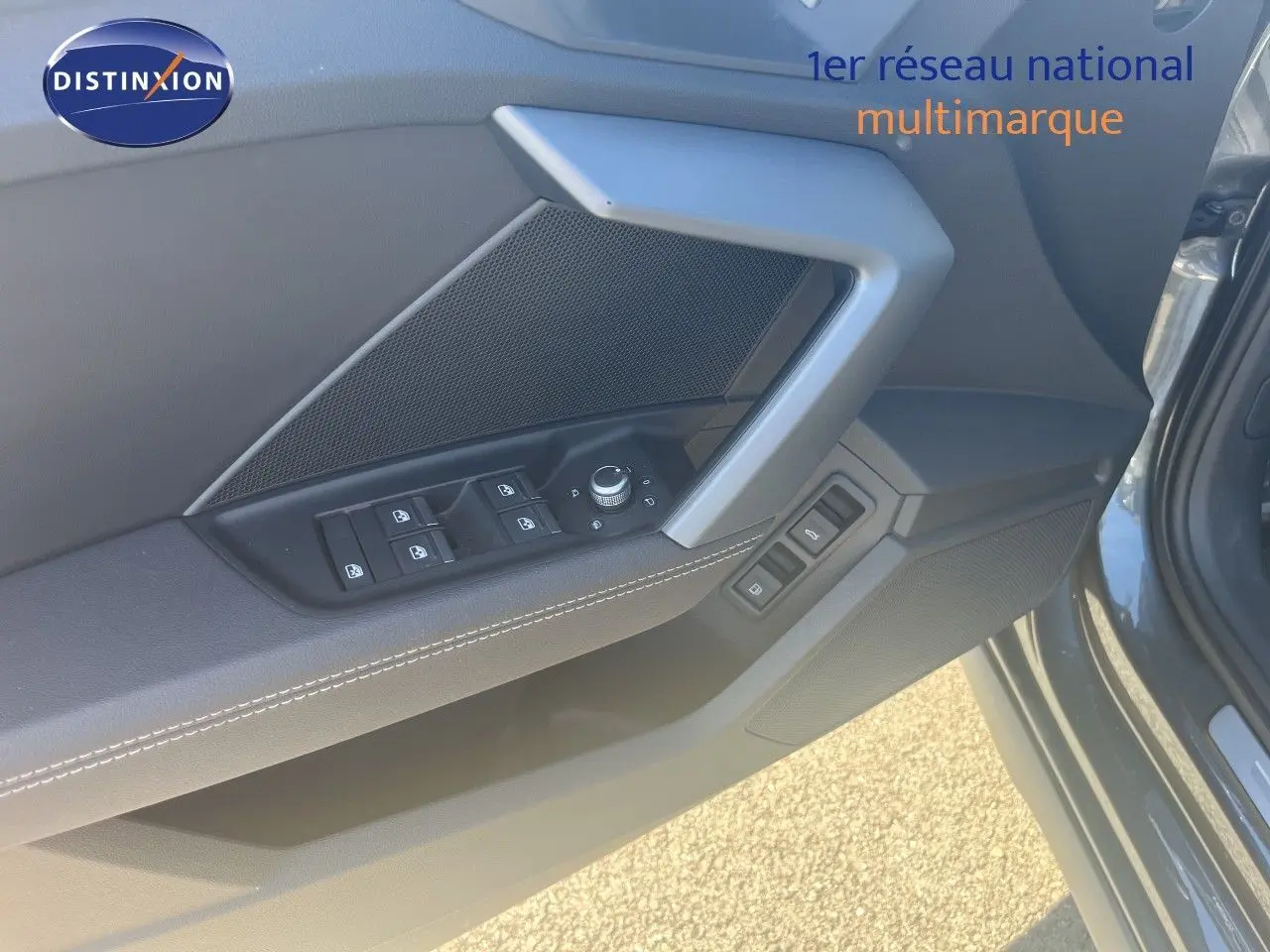 Détail de la porte avant gauche de l'Audi A3 Sportback gris Daytona, avec commandes des vitres et rétroviseurs.