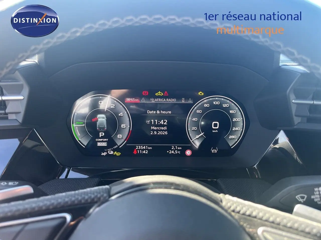 Vue rapprochée du tableau de bord numérique de l'Audi A3 Sportback 40 TFSIe gris Daytona, affichant vitesse et informations.