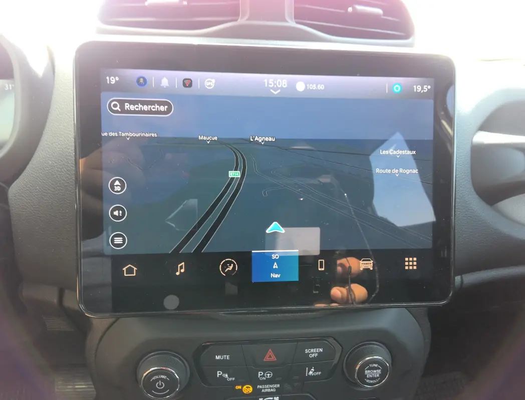 Écran tactile central du Jeep Renegade 2024 blanc, vue rapprochée du système de navigation et commandes.