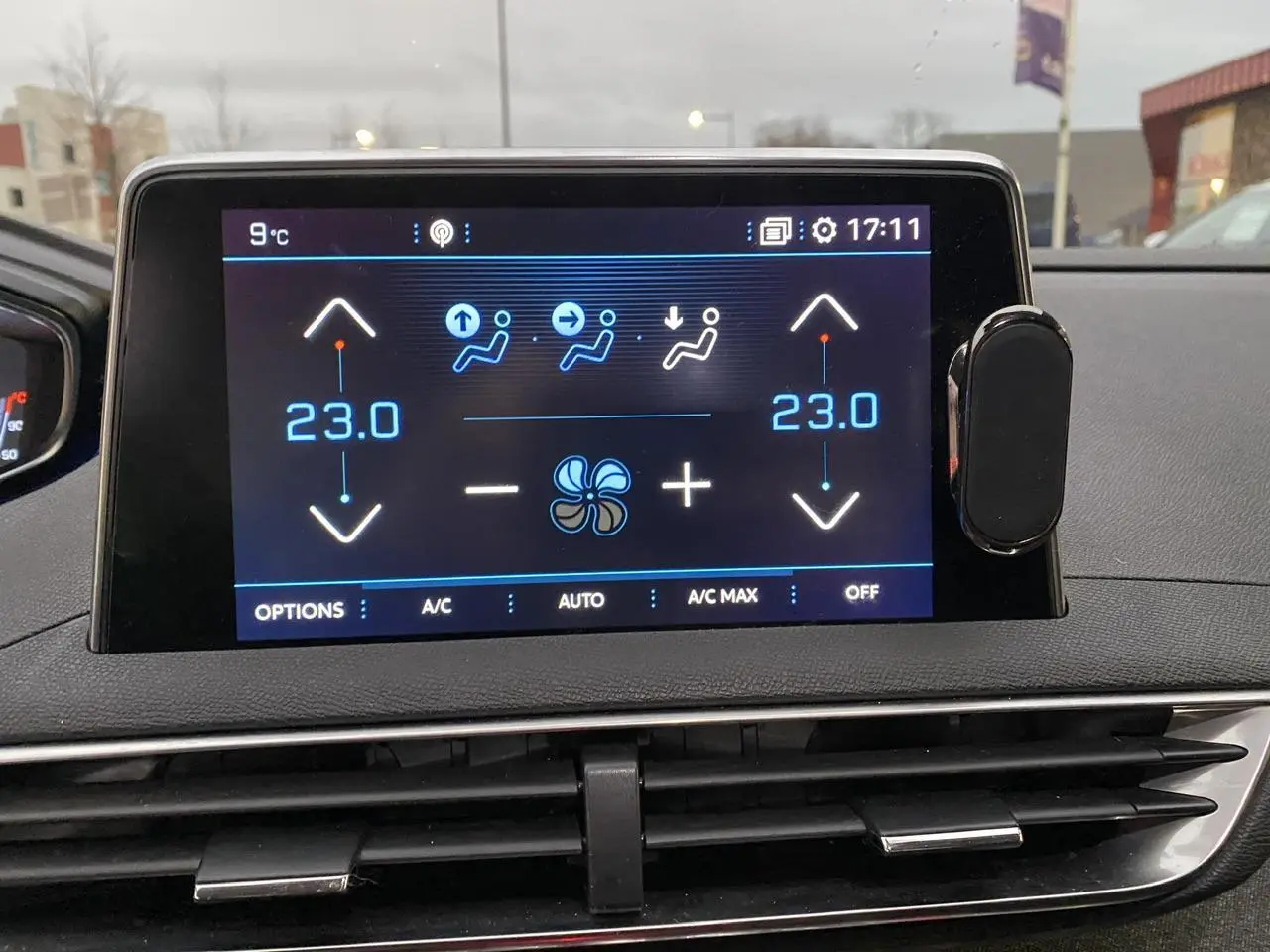 Écran tactile central du tableau de bord du Peugeot 3008 affichant la climatisation à 23°C en mode automatique.