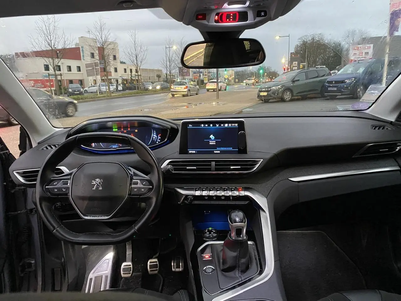 Vue intérieure du tableau de bord et volant du Peugeot 3008 gris Artense, avec écran tactile et levier de vitesse manuel.