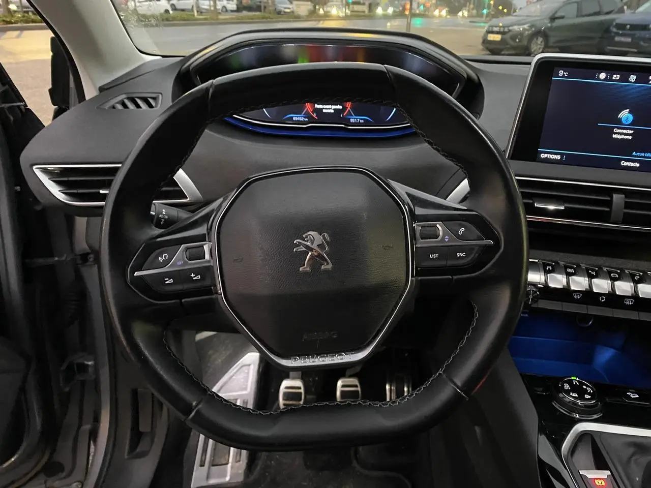 Vue rapprochée du volant cuir noir du Peugeot 3008 2019 avec tableau de bord digital et écran tactile central.