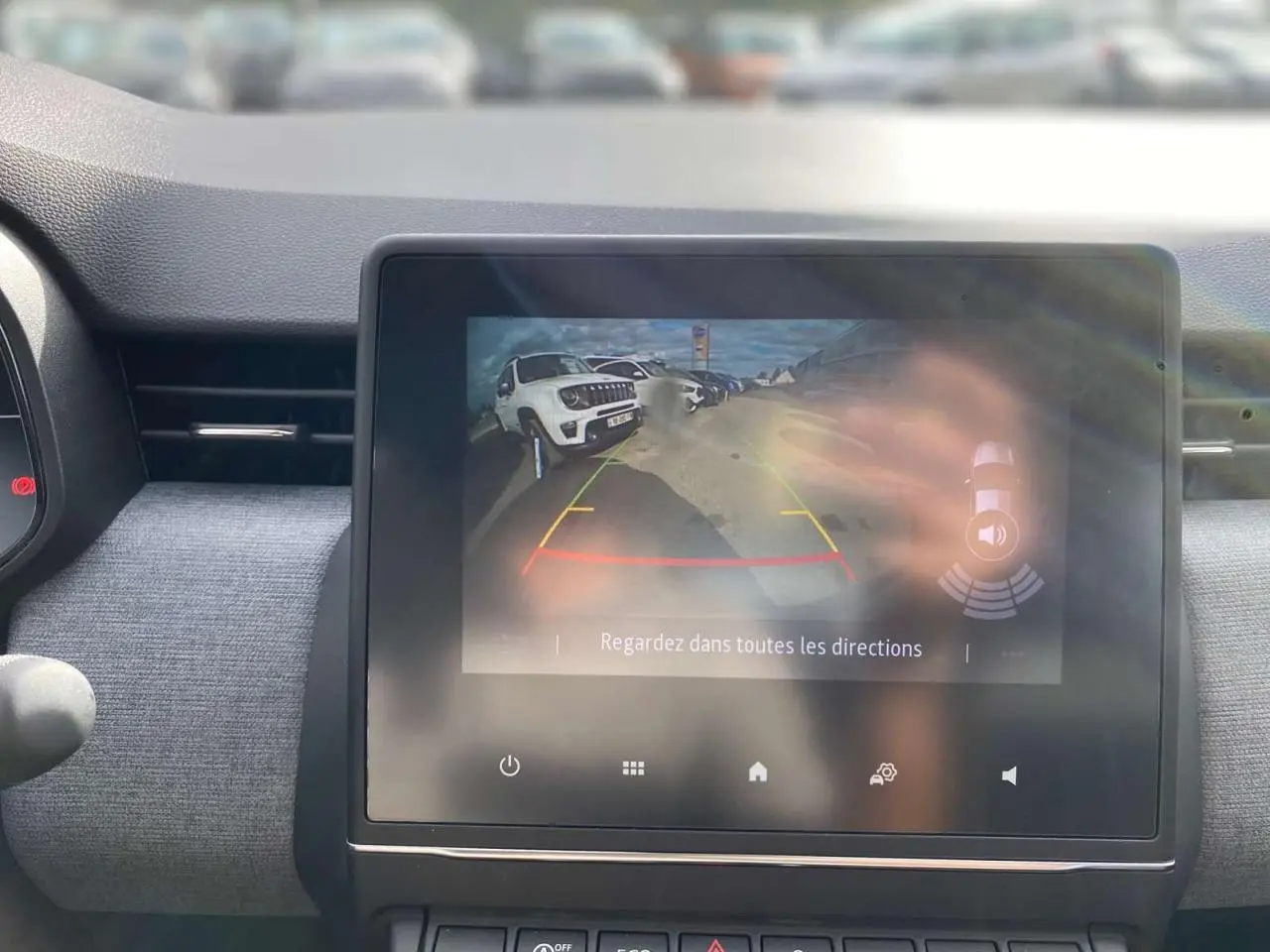 Écran tactile central affichant la caméra de recul de la Renault Clio 2025, avec vue arrière et guidage coloré.
