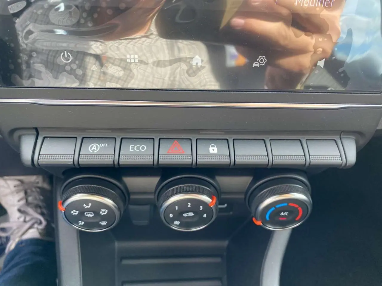 Gros plan sur la console centrale de la Renault Clio 2025 gris Rafale, montrant les commandes de climatisation manuelle et les boutons de fonction.