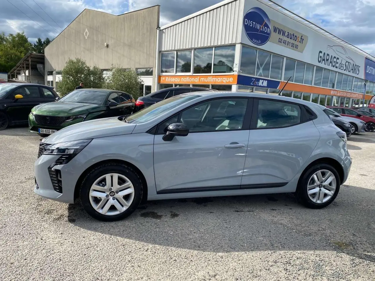 Profil latéral droit de la Renault Clio 2025 gris Rafale, avec jantes alliage et lignes modernes visibles en extérieur.