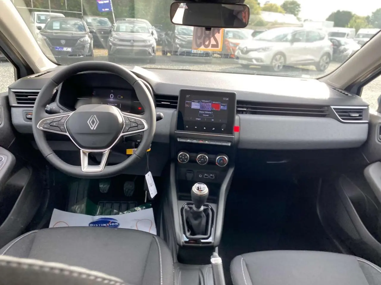 Vue intérieure avant de la Renault Clio 2025 gris Rafale, avec tableau de bord moderne et écran tactile central.