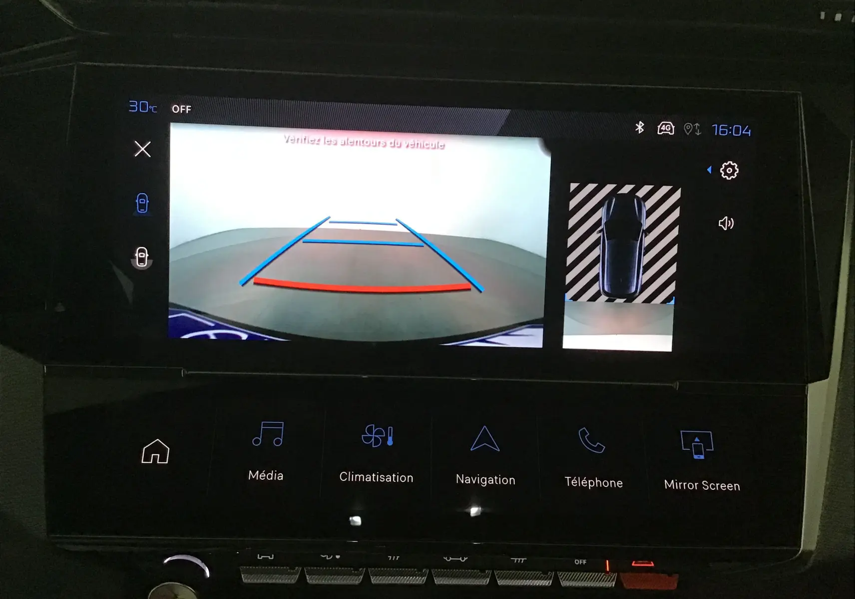 Écran multimédia de la Peugeot 308 gris Sellenium montrant la caméra de recul et l'affichage de l'aide au stationnement.