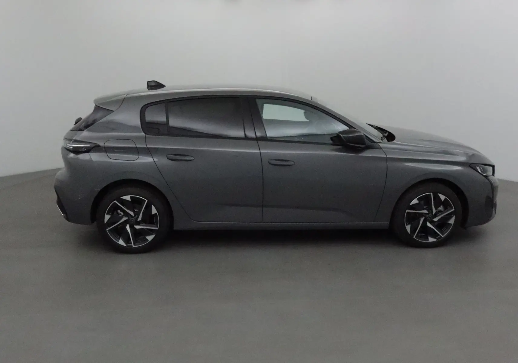 Profil côté gauche d'une Peugeot 308 gris Sellenium 2025, avec jantes alliage et lignes modernes épurées.