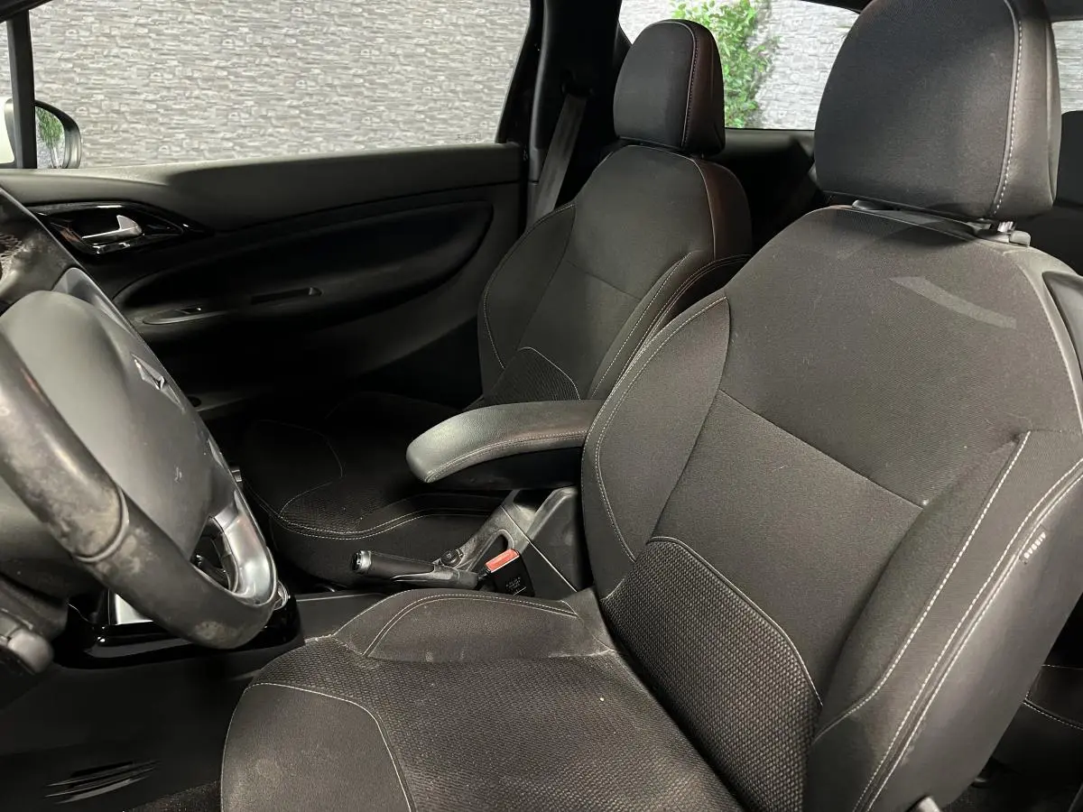 Vue intérieure rapprochée des sièges avant noirs et de la console centrale d'une DS3 So Chic 2016.