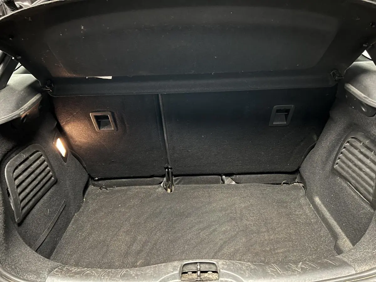 Coffre ouvert de DS3 violet 2016, vue intérieure montrant le tapis et l'éclairage latéral gauche.