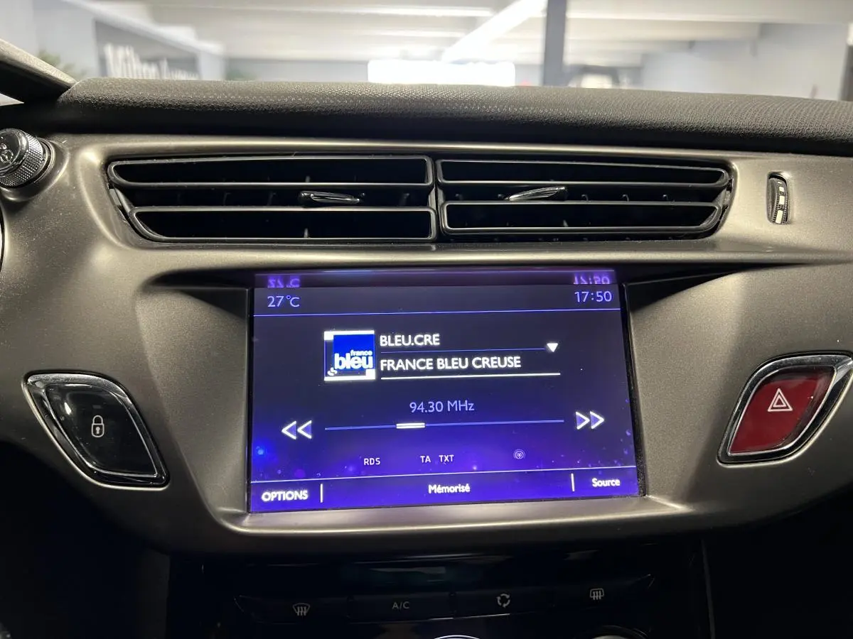 Écran tactile central allumé affichant la radio dans l'habitacle du DS3 violet de 2016, vue de face rapprochée.