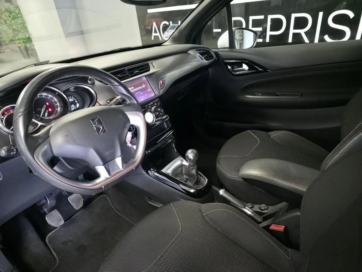 Intérieur noir de DS3 2016, vue côté conducteur avec volant cuir, tableau de bord et console centrale tactile.