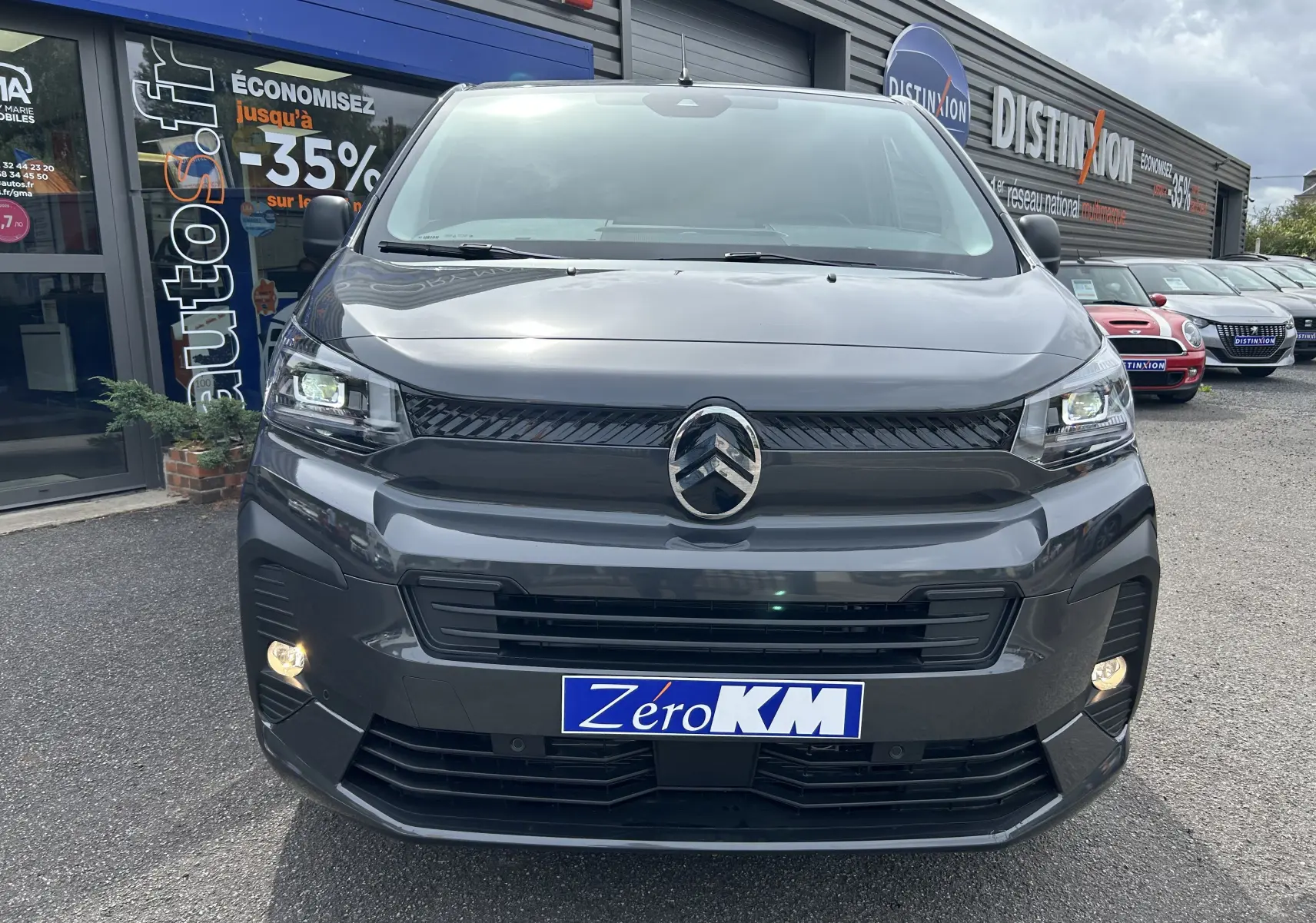 Vue frontale d'un Citroën Jumpy gris titane avec phares allumés et logo distinctif au centre de la calandre.