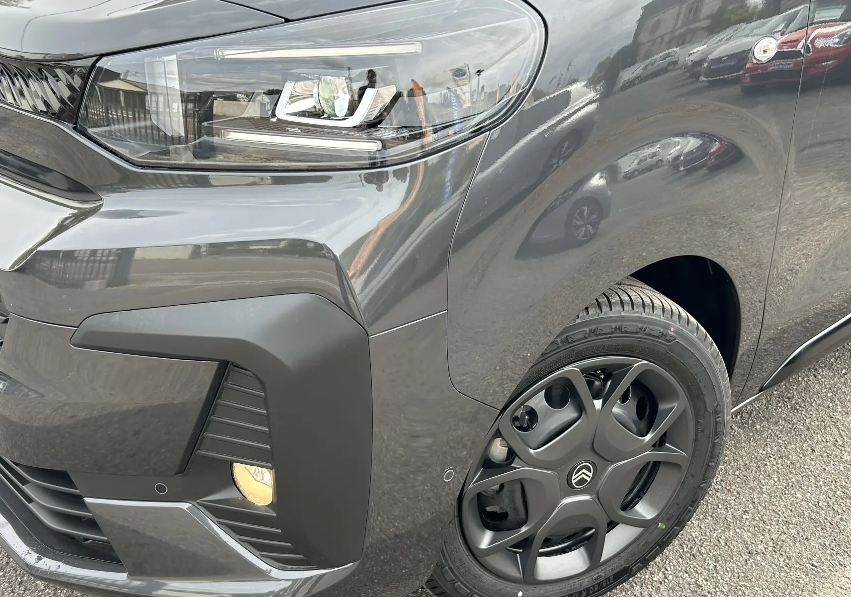Gros plan sur l'avant droit gris titane du Citroën Jumpy 2025, mettant en valeur le phare LED et la roue au design moderne.