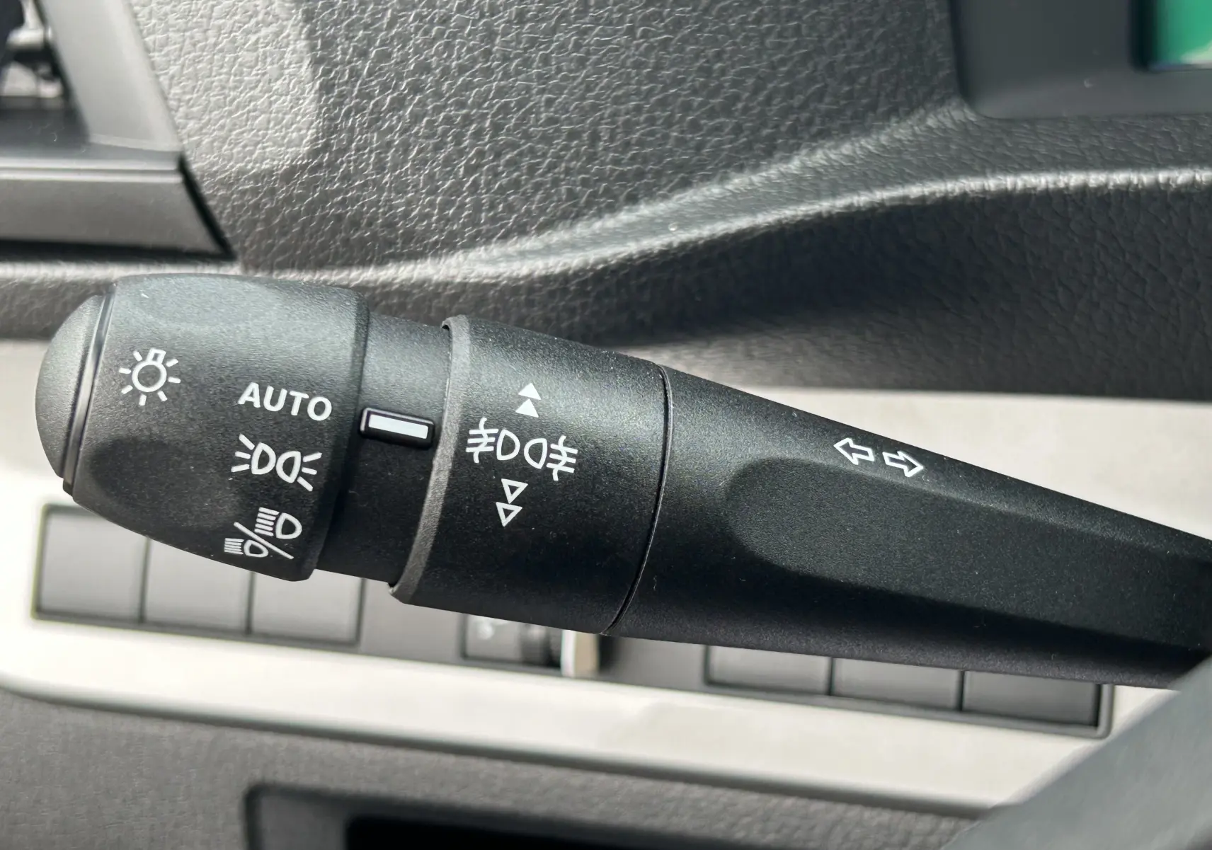 Gros plan sur la manette de commande des phares et clignotants dans l'habitacle du Citroën Jumpy gris titane.