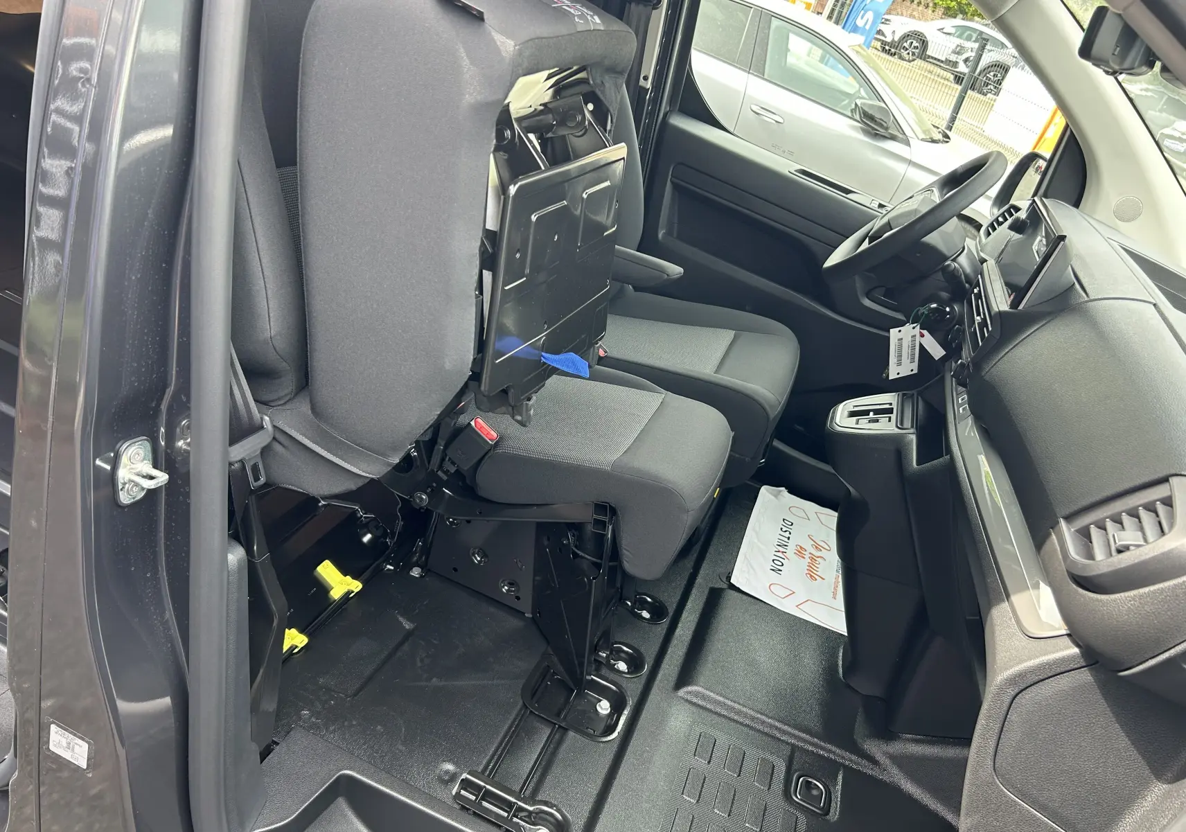 Intérieur du Citroën Jumpy gris titane 2025 vu côté conducteur, sièges avant en tissu avec siège relevé.