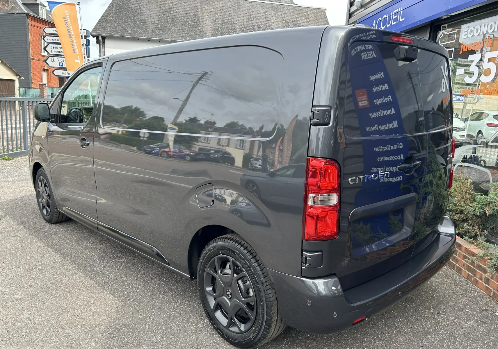 Vue 3/4 arrière droite du Citroën Jumpy gris titane 2025, fourgon utilitaire avec feux arrière rouges et jantes noires.