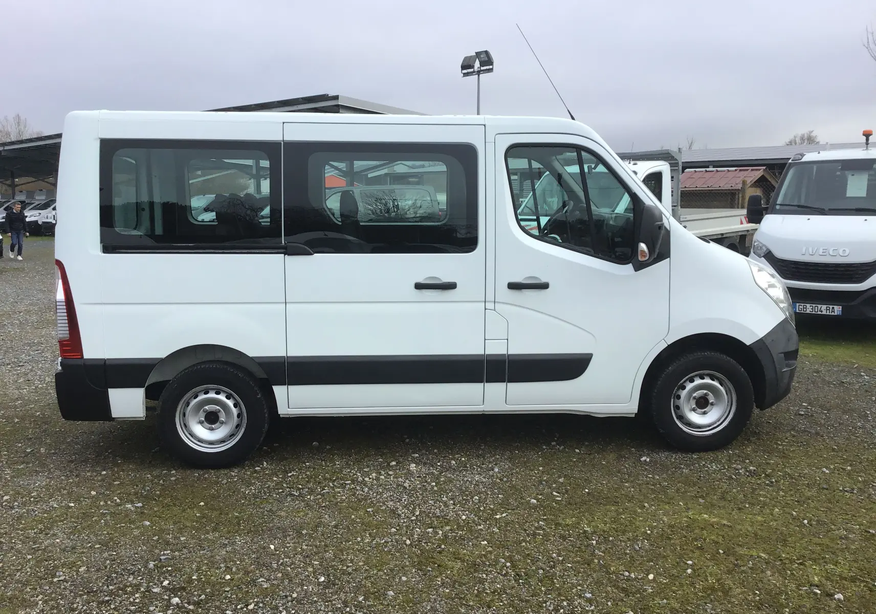 Profil côté droit d’un Renault Master Combi III blanc de 2017, avec fenêtres teintées et jantes acier simples.
