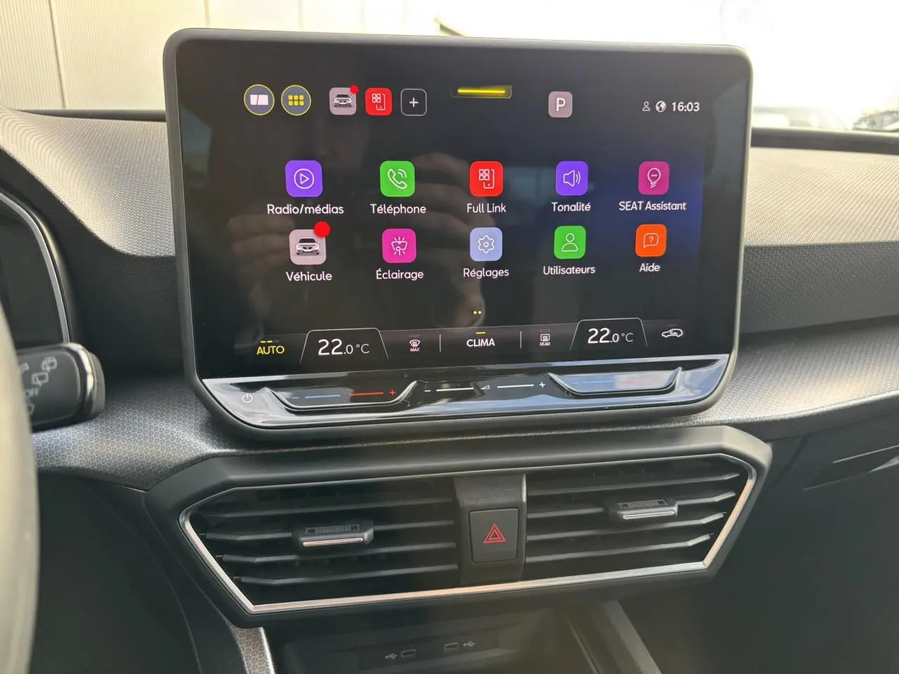 Écran tactile central du tableau de bord de la SEAT LEON 2025 avec interface connectée et commandes climatiques.