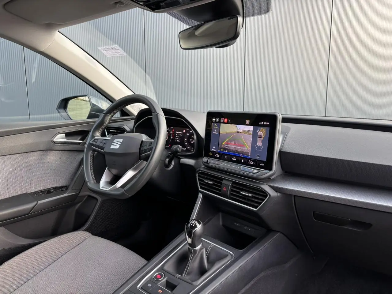 Vue intérieure côté conducteur du SEAT Leon 2.0 TDI 115 Style 2025, avec écran tactile affichant la caméra de recul.